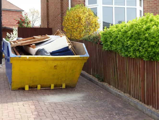 yellow skip in a driveway